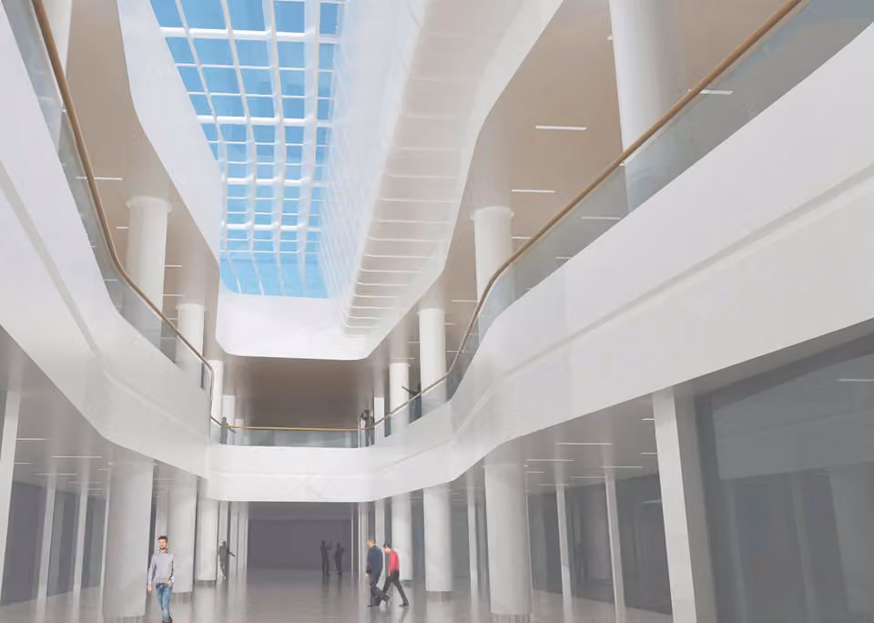Interior of a white atrium with a skylight, curved balustrades and slender columns.